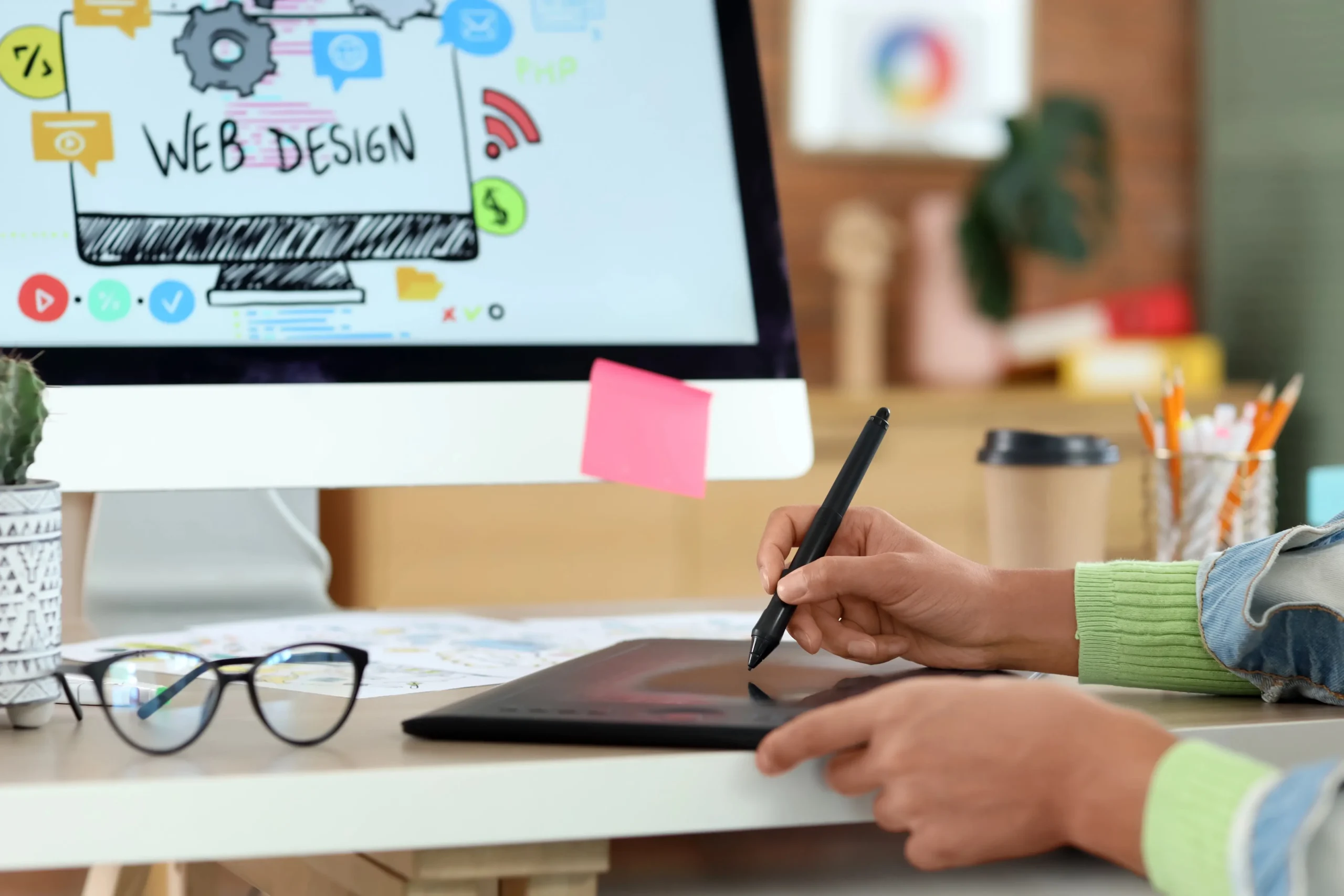 Person using a stylus on a digital tablet at a desk.